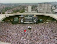 View-of-audience-and-stage-at-Queen-Live-Aid-1985-Wembley-UK-Note-the-relatively-small.png