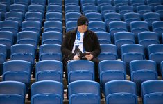 brighton-fans-readfing-programme-in-seats-newcastle-united-nufc-500x750.jpg