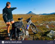 side-view-of-a-female-biker-on-landscape-pointing-towards-the-mountain-C5E1JB.jpg